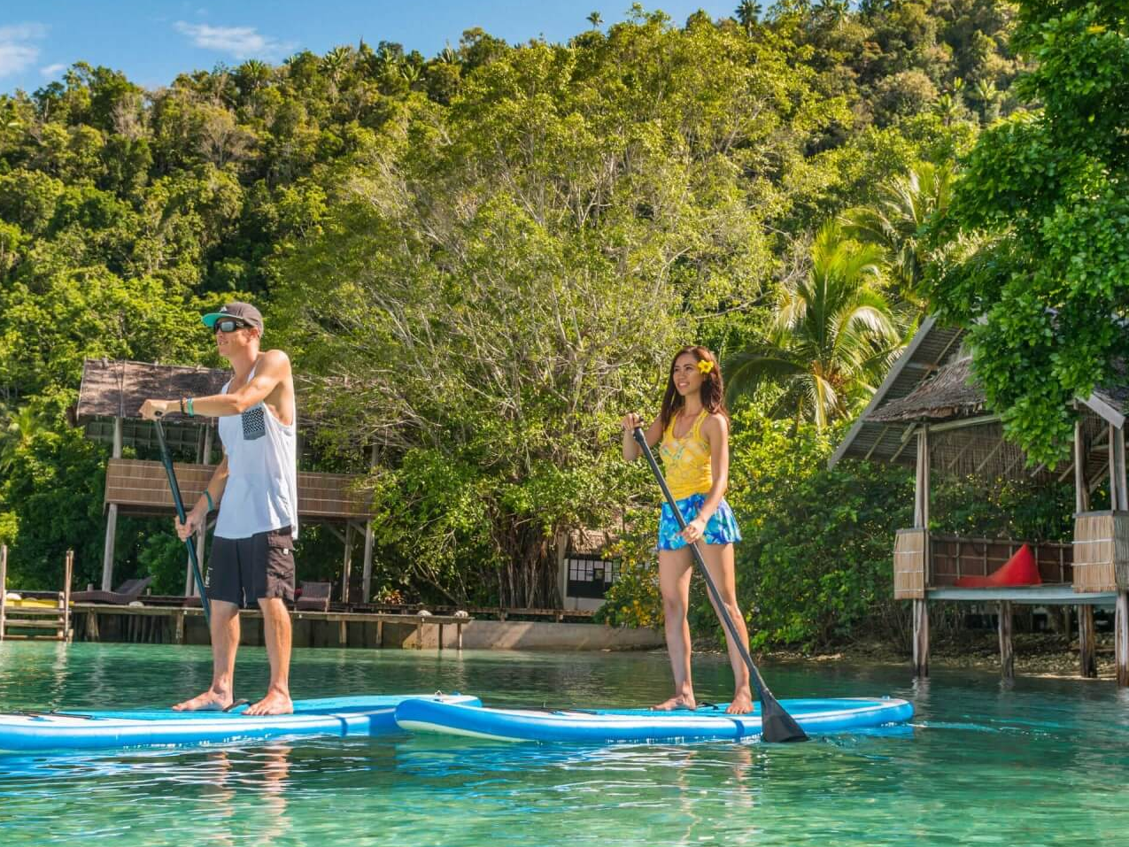 two people stand-up paddleboarding at Kri Eco Resort, Raja Ampat Resort
