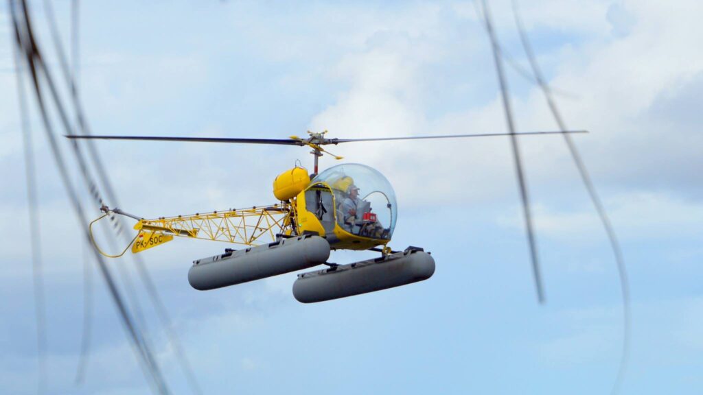 Max ammer, papua diving resorts founder, flying a helicopter (which he built himself)